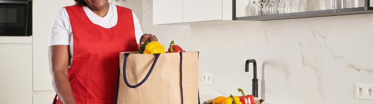 Huishoudhulp pakt de boodschappen uit