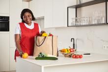Huishoudhulp pakt de boodschappen uit